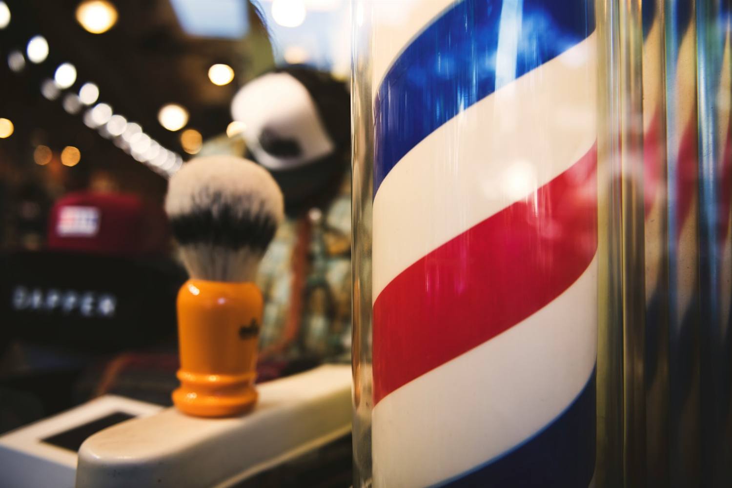 Barber pole turning next to a shaving brush